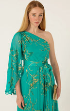 Model wearing one-shoulder neckline and dramatic fluted sleeve Sacha Drake Lorelei Maxi Dress in jade green and gold floral print